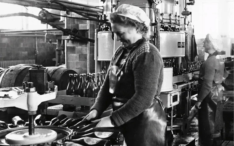 Frau an halb&shy;auto&shy;mati&shy;scher Etikettiermaschine, Bild in schwarz wei&szlig; aus 1951