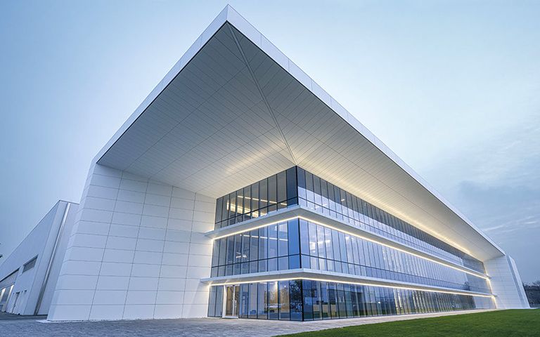 Hauptsitz von System Logistics, Gebäude mit großem Dachvorsprung und Glasfront