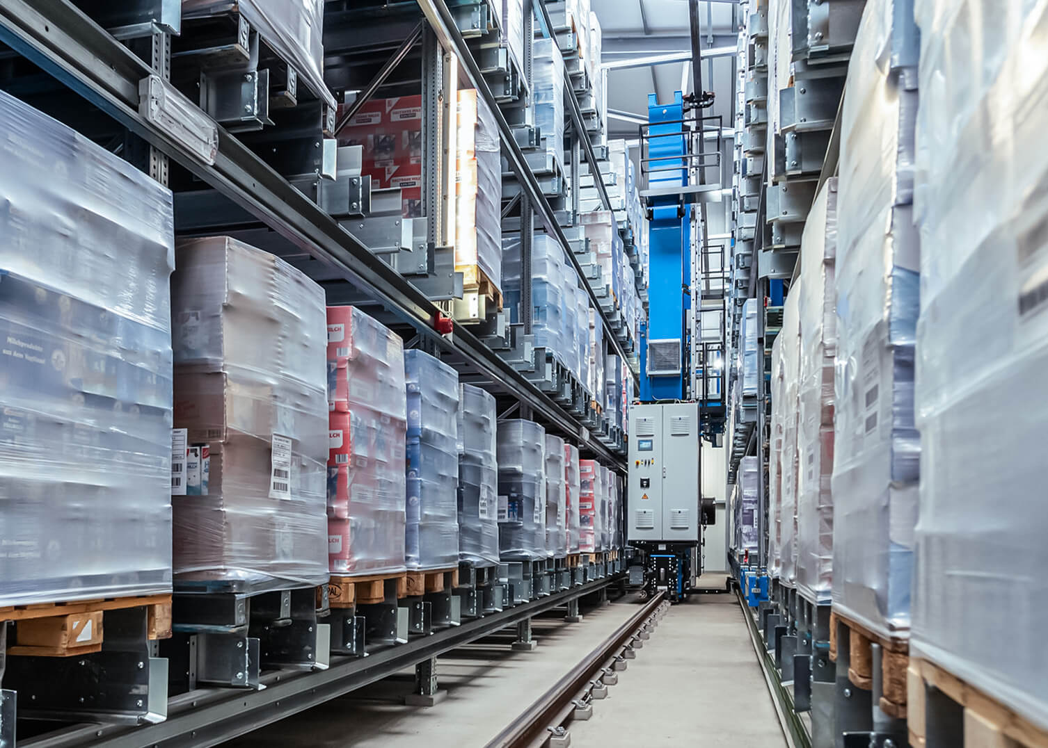 Aisle in the compact warehouse from System Logistics with pallets on the sides and driverless vehicle on rails