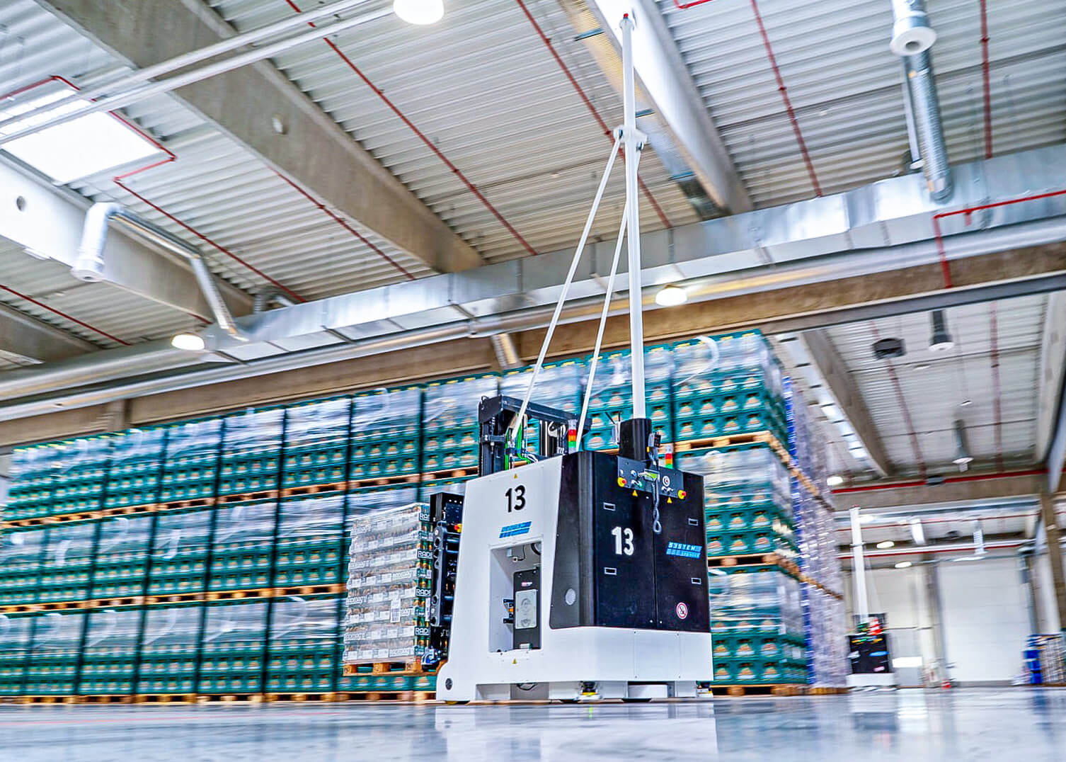 Fahrerloses Transportsystem (AGV) von System Logistics transportiert eine Palette mit Getr&auml;nkekisten