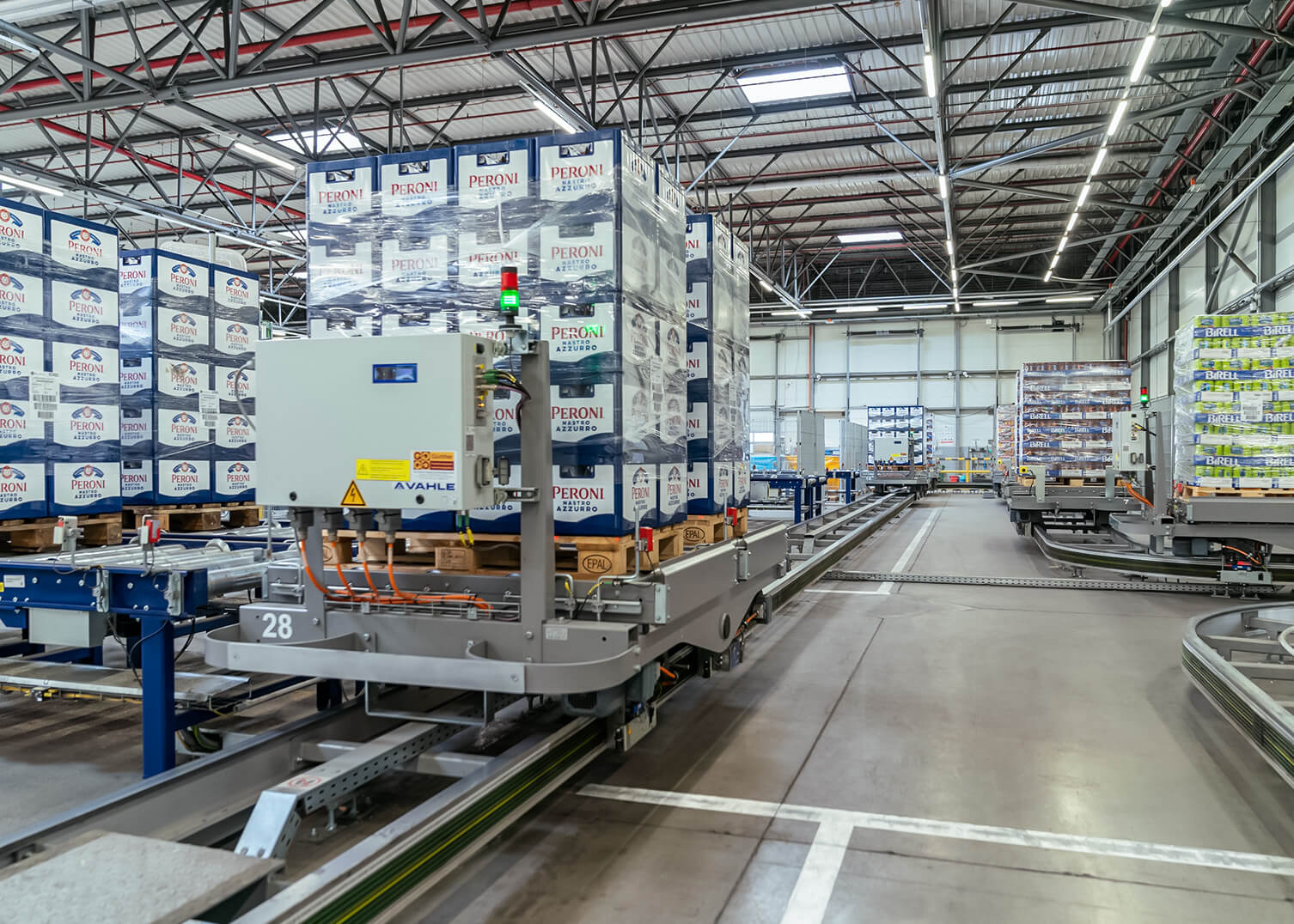 Palettenwagen von System Logistics transportiert Getr&auml;nkek&auml;sten auf Schienensystem ins Hochregallager