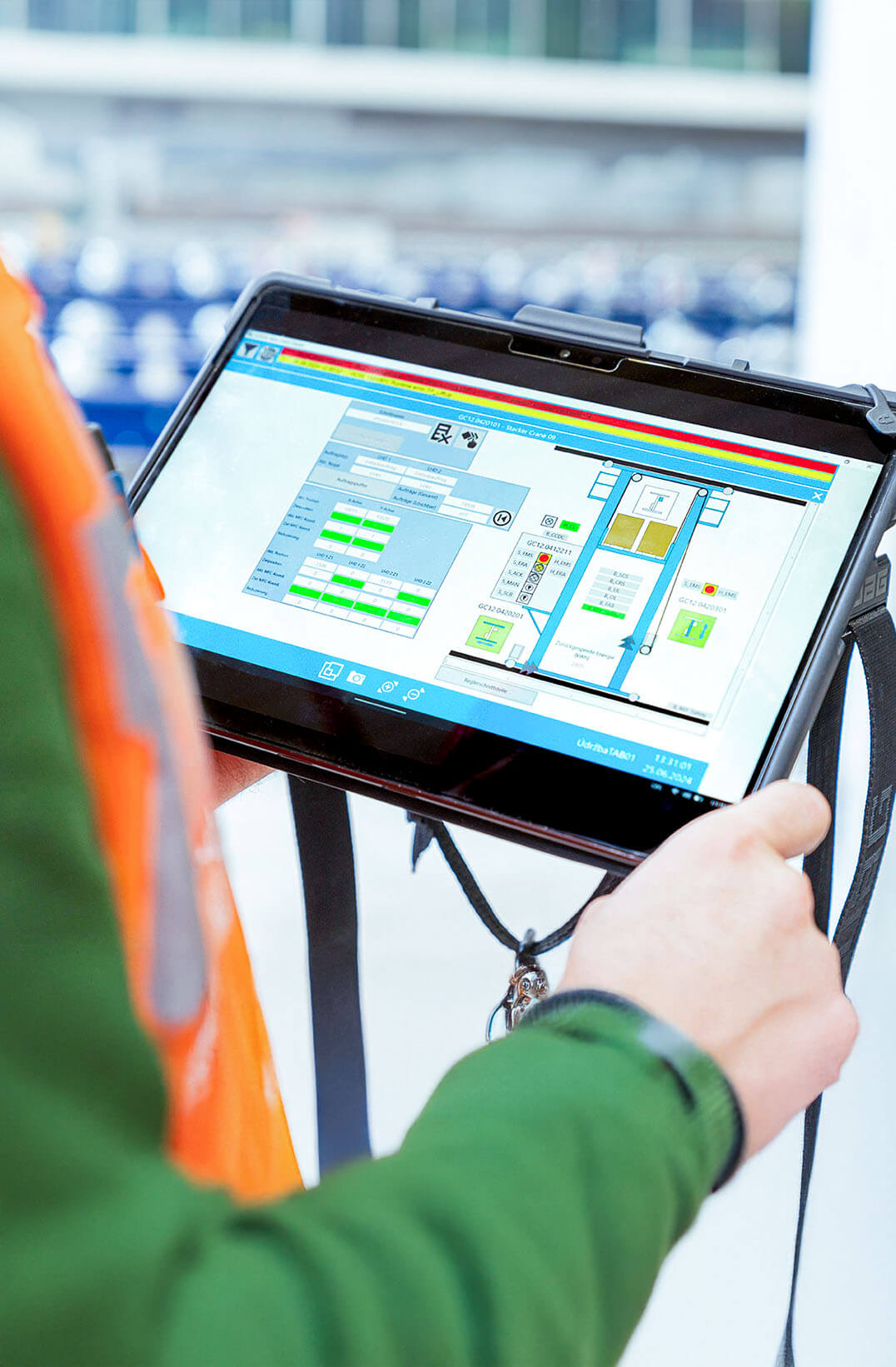 Mitarbeiter von System Logistics blickt auf Tablet mit Steuerungssoftware f&uuml;r Intralogistik und AGV-Systeme