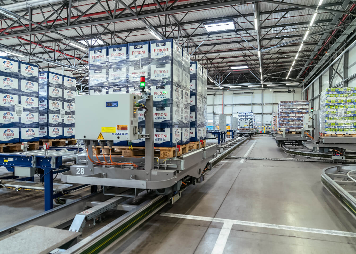 Palettenwagen von System Logistics transportiert Getr&auml;nkek&auml;sten auf Schienensystem ins Hochregallager