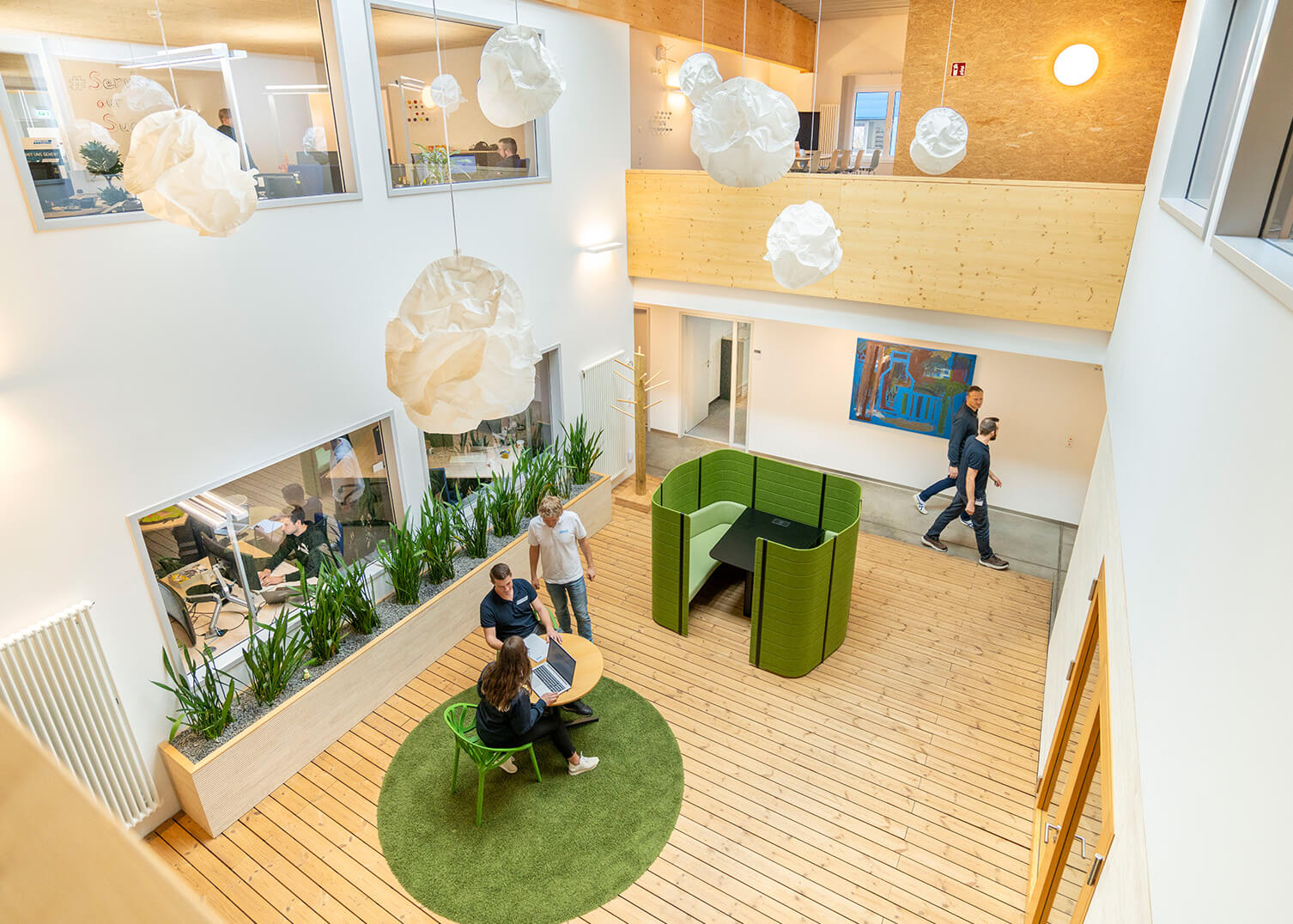 Blick von oben auf offenen Mitarbeiterbereich bei System Logistics in Wackersdorf, mehrere Mitarbeiter zu sehen